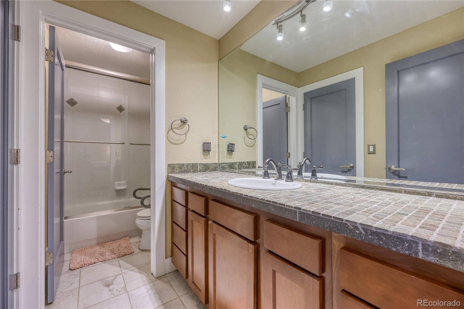 7963 Glen Ridge Drive Castle Pines, CO 80108 - Photo 36 of 48 a bathroom with a granite countertop sink a toilet and shower