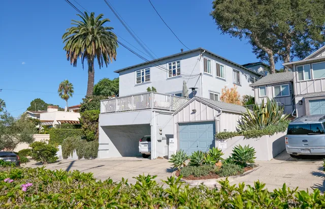 a view of a house with a yard and potted plants