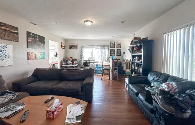 a living room with furniture and wooden floor