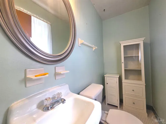 a bathroom with a sink a toilet and a mirror