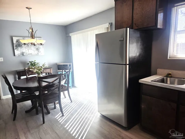a kitchen with a refrigerator a dining table and chairs