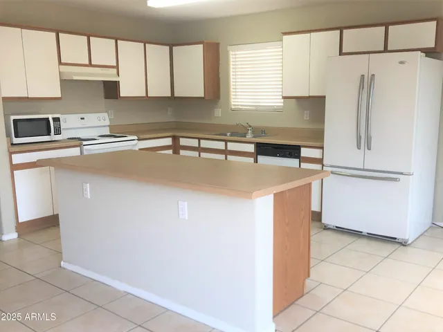 a kitchen with a refrigerator a stove a sink and a cabinets