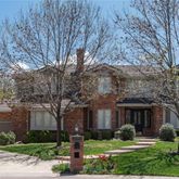 a front view of a house with garden and trees