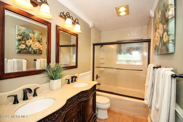 a bathroom with a granite countertop sink mirror vanity and toilet