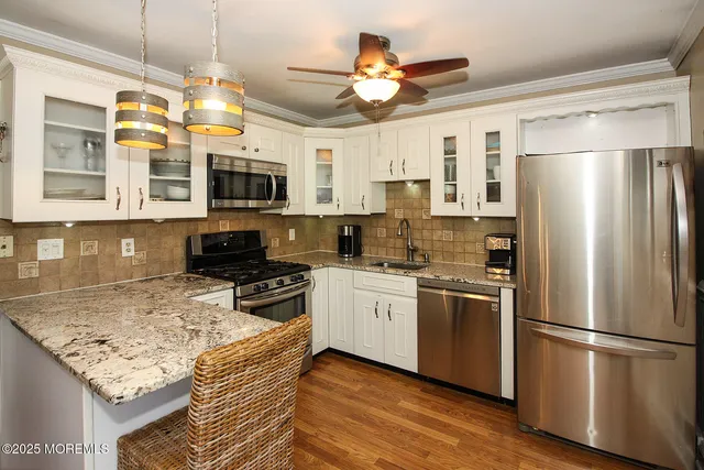 a kitchen with stainless steel appliances granite countertop a refrigerator a stove top oven a sink and dishwasher