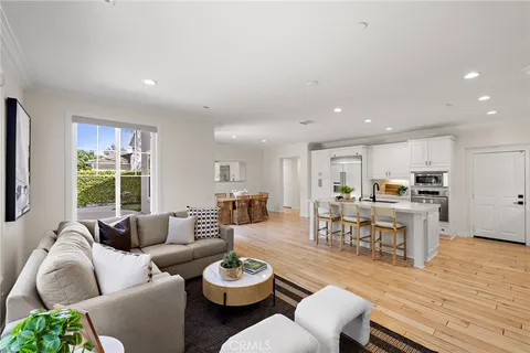 a living room with furniture kitchen and a large window