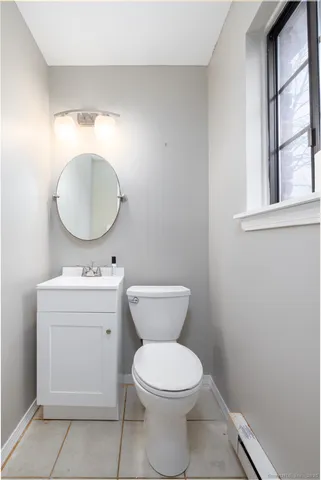 a bathroom with a toilet a sink and mirror