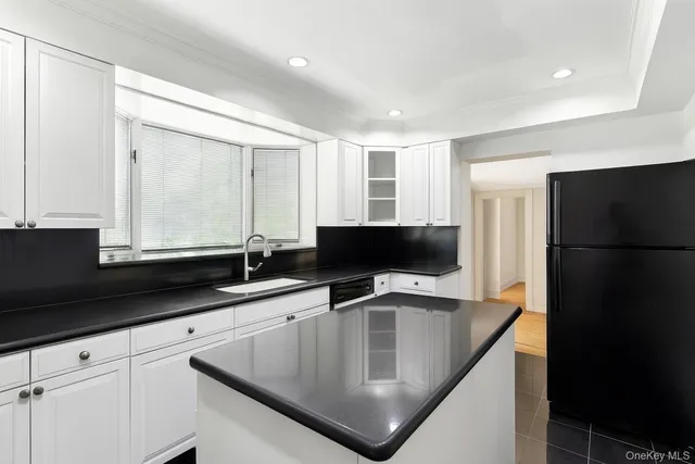 a kitchen with stainless steel appliances granite countertop a sink a refrigerator and a granite counter tops