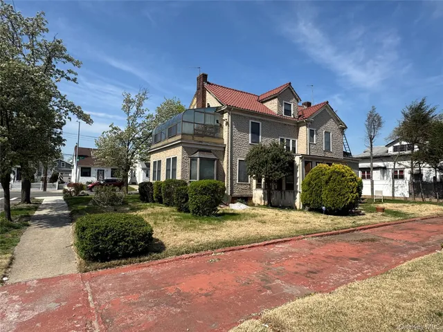 a front view of a house with yard and tress