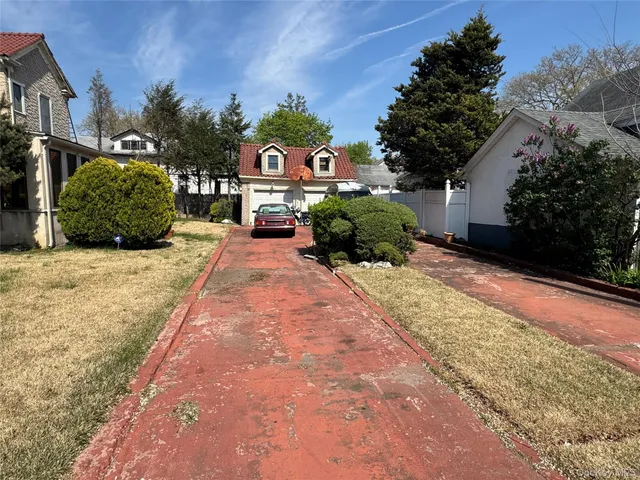 a front view of a house with a yard and potted plants