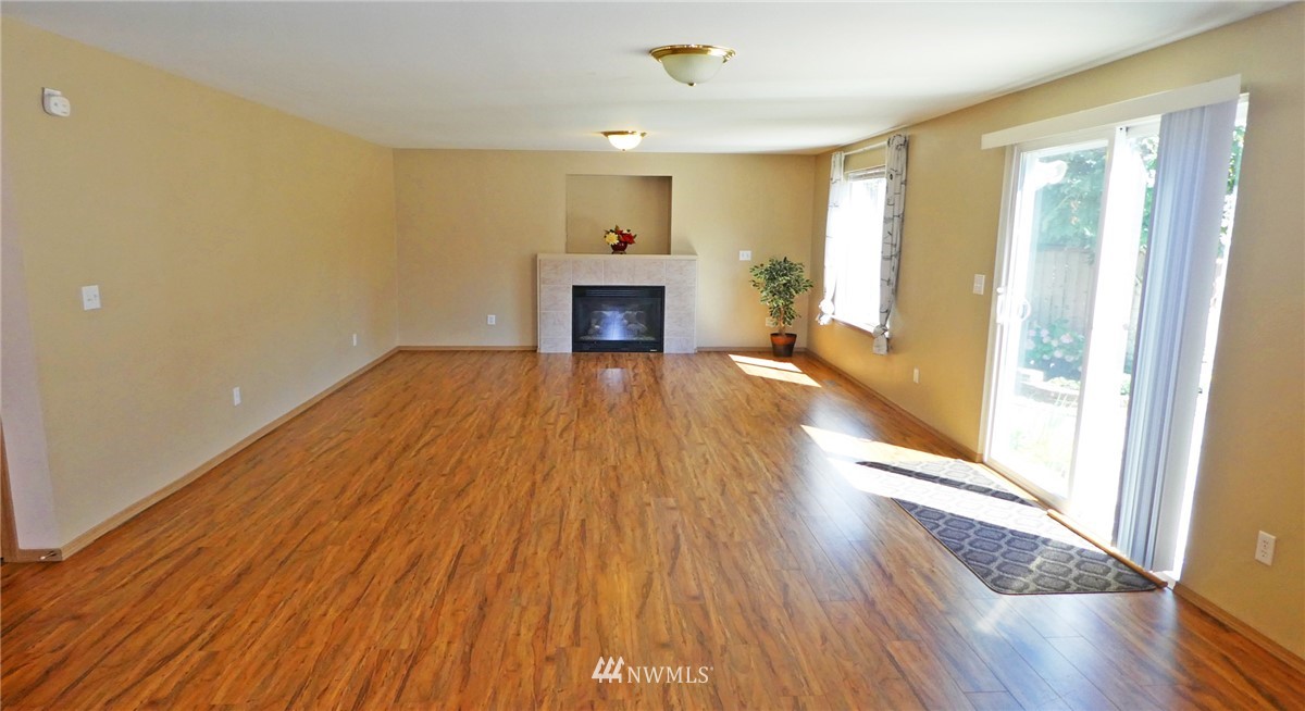 2513 Hidden Springs Loop Southeast Lacey, WA 98503 - Photo 11 of 40 a view of a livingroom with wooden floor and a fireplace