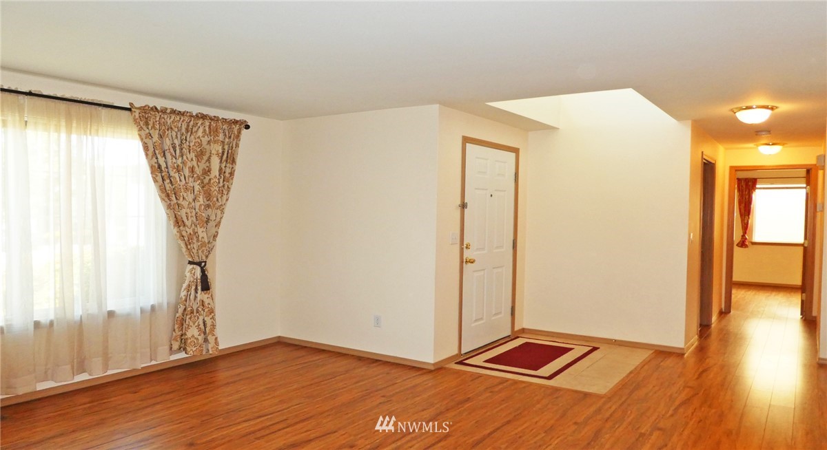 2513 Hidden Springs Loop Southeast Lacey, WA 98503 - Photo 4 of 40 a view of an empty room with wooden floor and a window