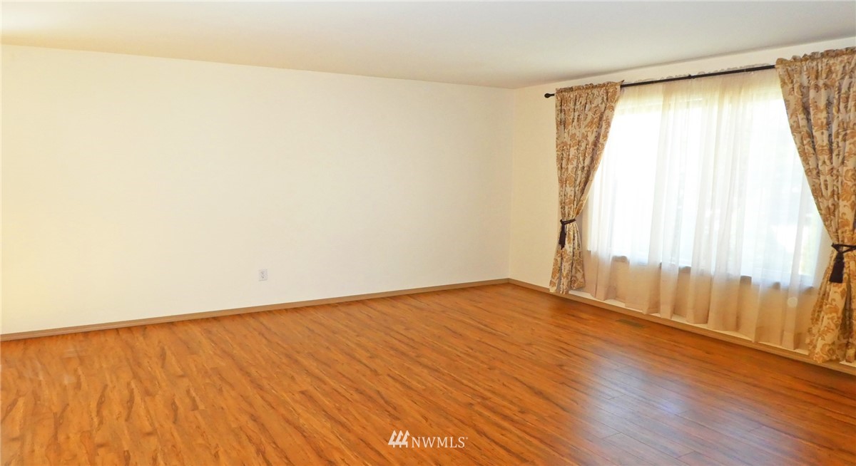2513 Hidden Springs Loop Southeast Lacey, WA 98503 - Photo 5 of 40 a view of an empty room with wooden floor and a window