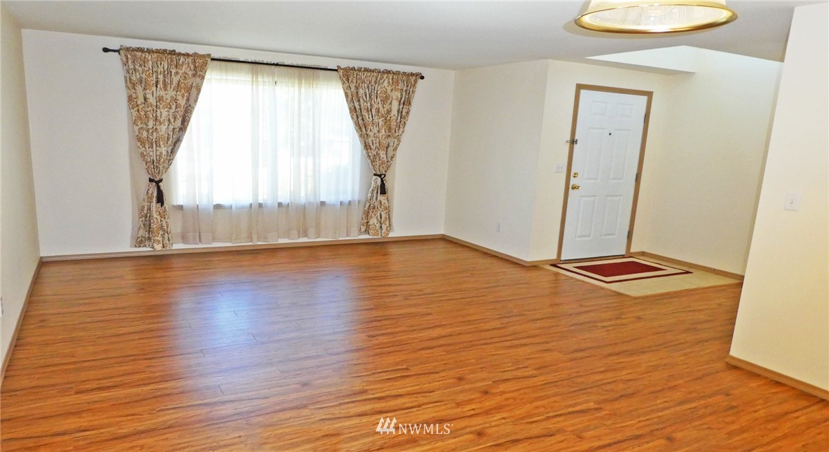 2513 Hidden Springs Loop Southeast Lacey, WA 98503 - Photo 6 of 40 a view of an empty room with wooden floor and a window