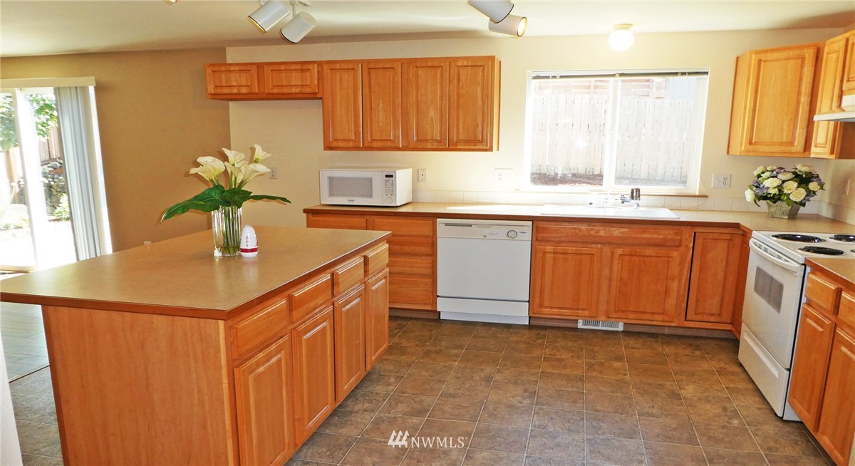 2513 Hidden Springs Loop Southeast Lacey, WA 98503 - Photo 8 of 40 a kitchen with stainless steel appliances a sink stove and cabinets