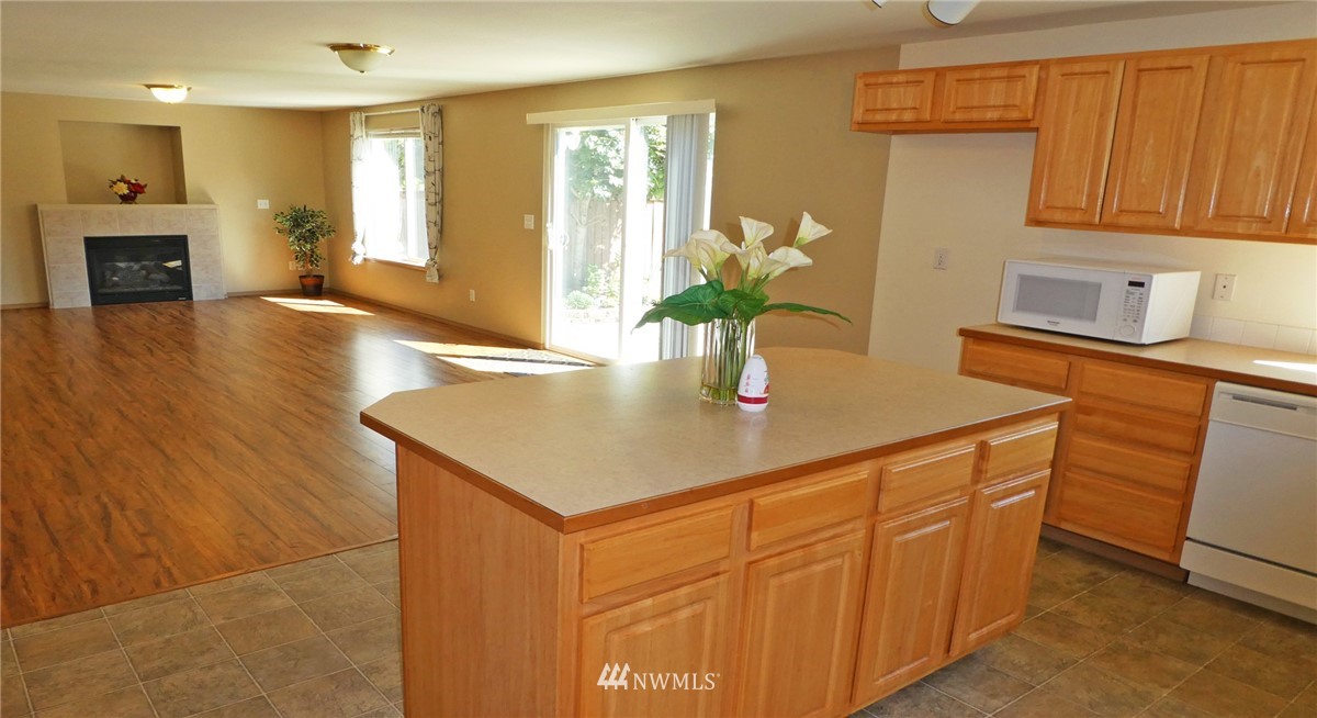 2513 Hidden Springs Loop Southeast Lacey, WA 98503 - Photo 9 of 40 a kitchen with stainless steel appliances granite countertop a sink a microwave cabinets and wooden floor