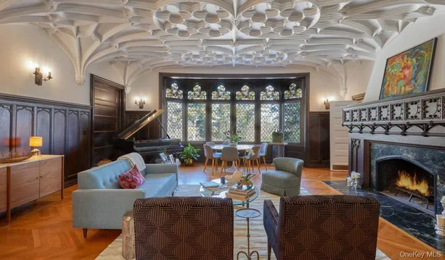 a living room with furniture a fireplace and a floor to ceiling window