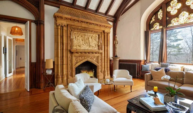 a living room with furniture fireplace and a large window