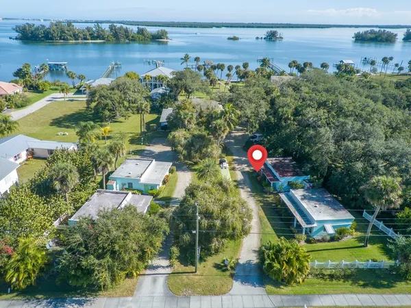 an aerial view of a house with a yard and lake view