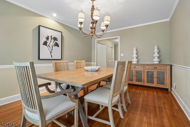 106 Division Avenue Summit, NJ 07901 - Photo 9 of 38 a dining room with wooden floor a chandelier a wooden table and chairs