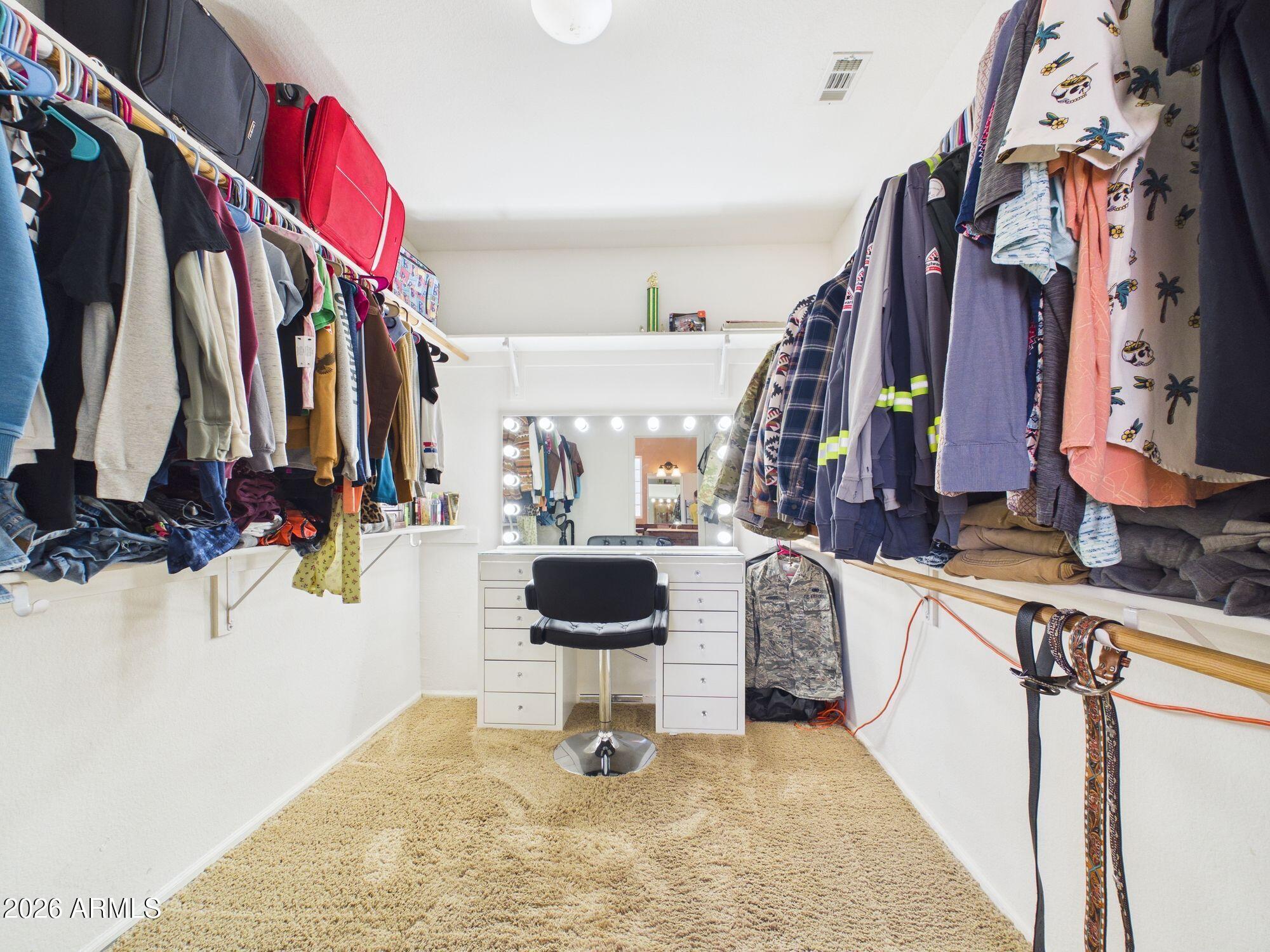 51491 West Dune Shadow Road Maricopa, AZ 85139 - Photo 12 of 33 a view of walk in closet with clothes and shoes