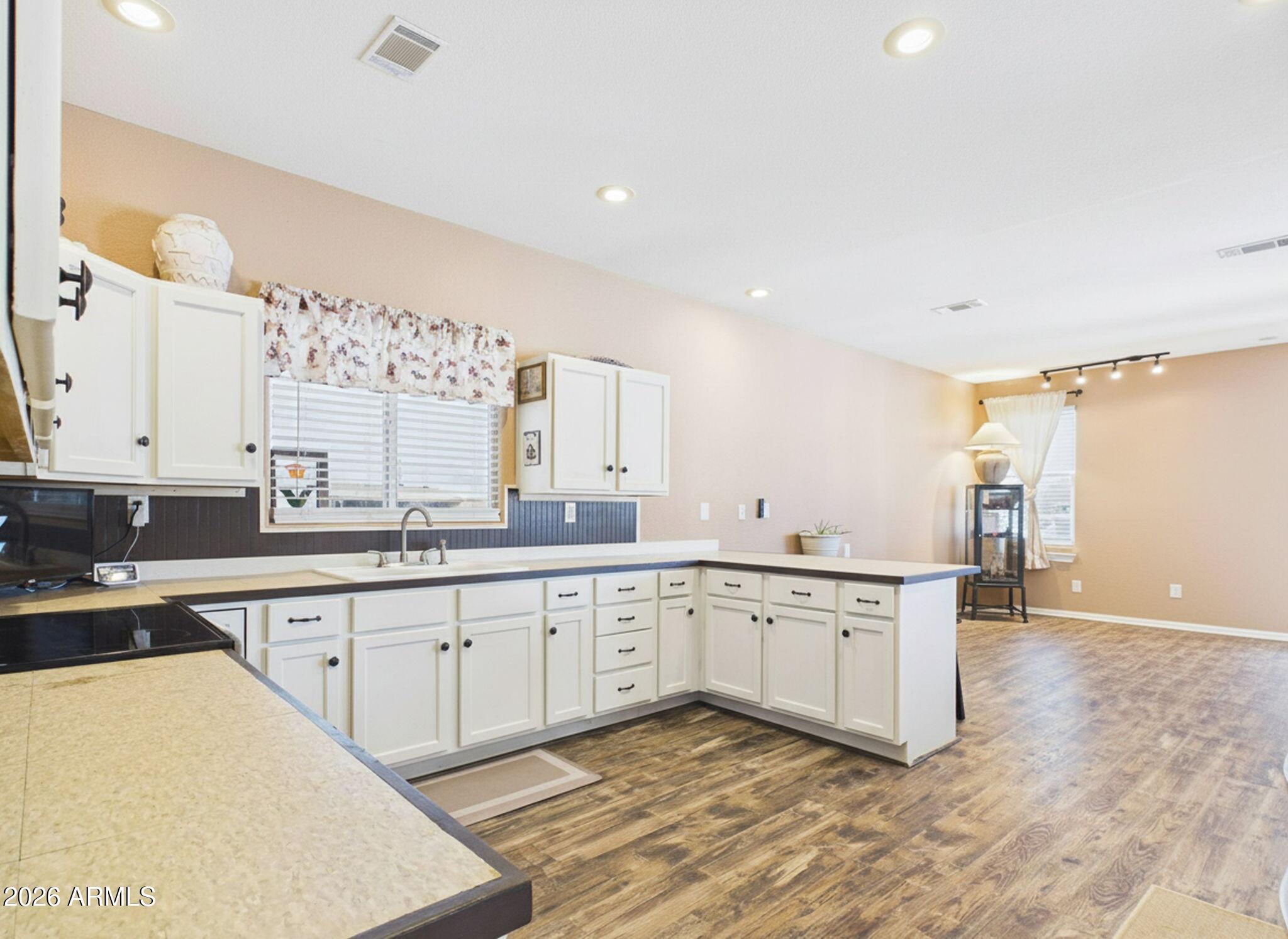 51491 West Dune Shadow Road Maricopa, AZ 85139 - Photo 3 of 33 a large white kitchen with a sink and cabinets