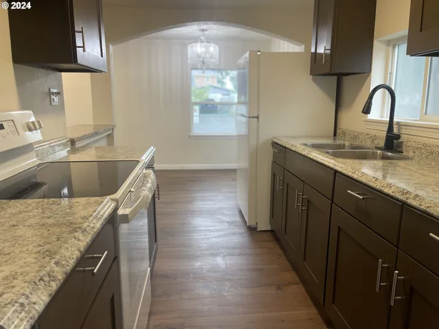 a kitchen with kitchen island granite countertop a sink and wooden cabinets