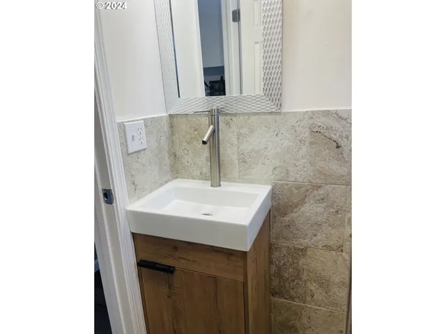 a bathroom with a sink a mirror and a window