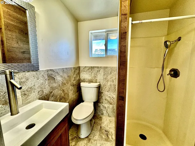 a bathroom with a sink a toilet and shower