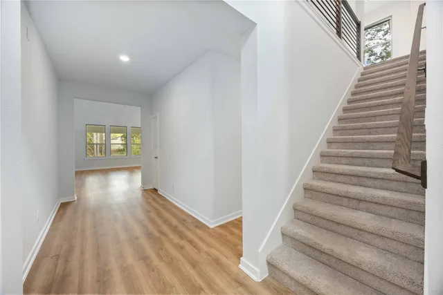 a view of entryway and hall with wooden floor