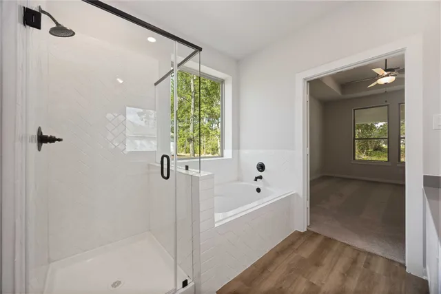 a bathroom with a bathtub a window and a shower