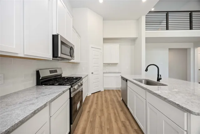 a kitchen with stainless steel appliances granite countertop a stove and a sink