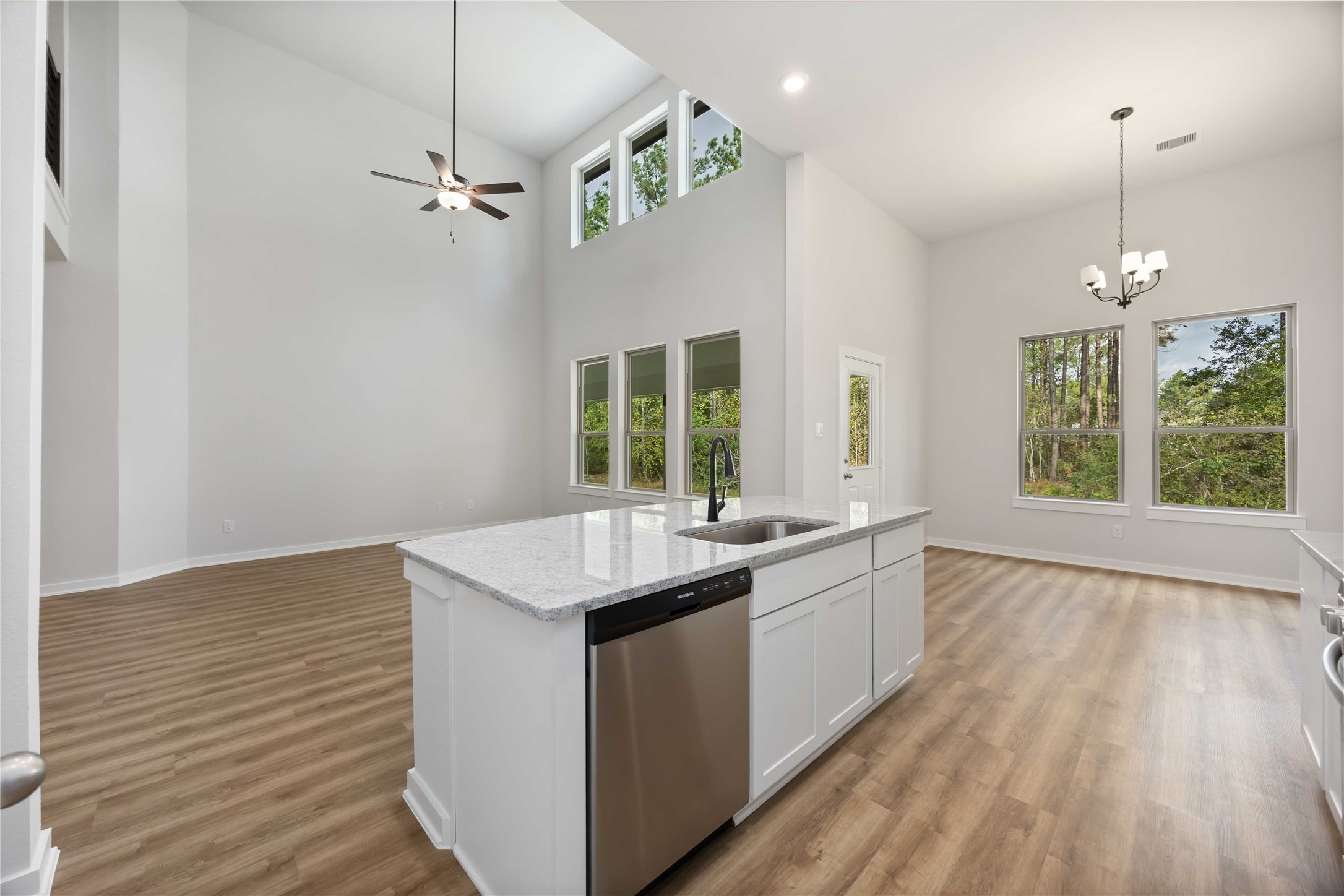 13511 Caldwell Street Conroe, TX 77303 - Photo 9 of 29 a kitchen with a sink dishwasher a stove and white countertops with wooden floor