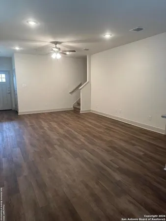 an empty room with wooden floor closet and windows