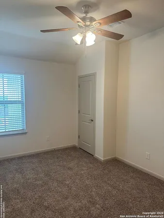 en empty room with windows and fan