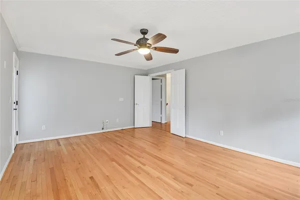 a view of an empty room and chandelier fan