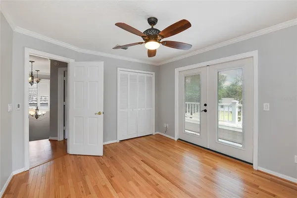 a view of empty room with wooden floor and ceiling fan