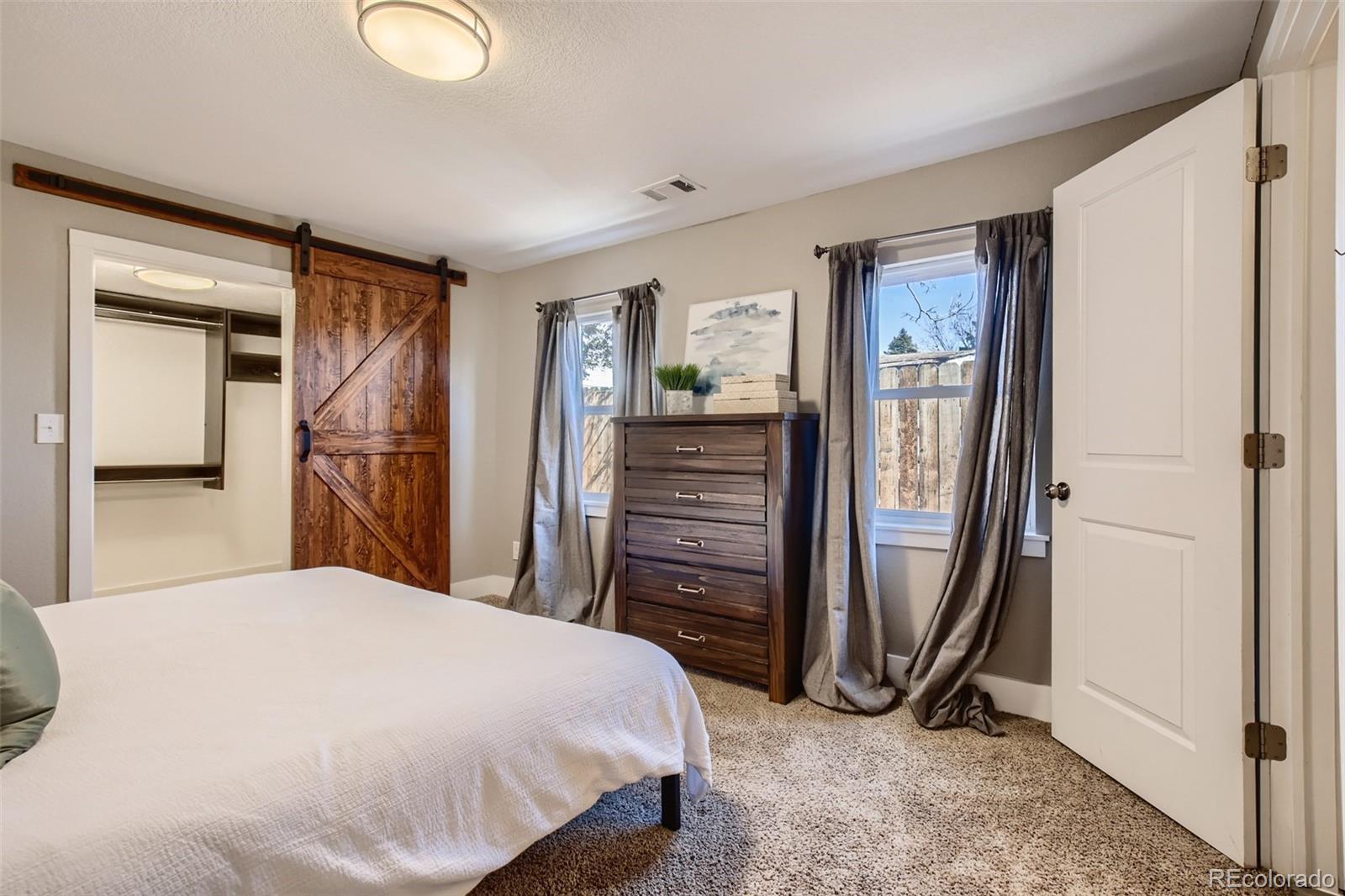 2310 South Decatur Street Denver, CO 80219 - Photo 11 of 27 a bedroom with a bed and a mirror