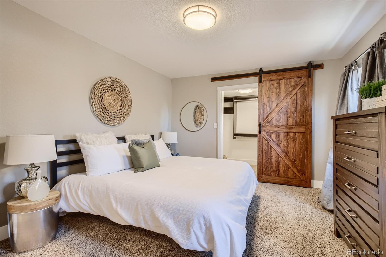 2310 South Decatur Street Denver, CO 80219 - Photo 12 of 27 a bedroom with a bed and a chandelier