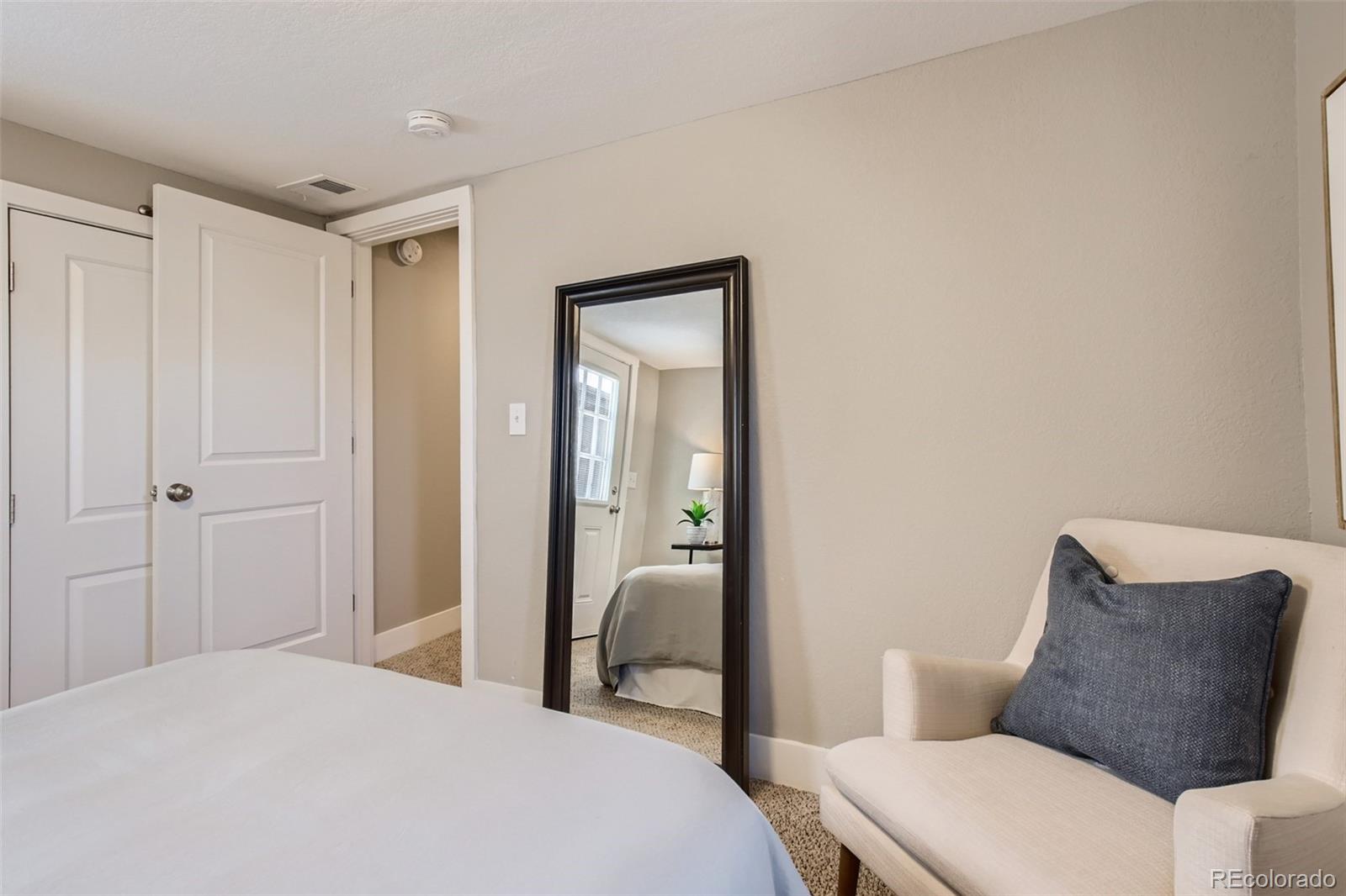 2310 South Decatur Street Denver, CO 80219 - Photo 18 of 27 a bedroom with a bed and a mirror