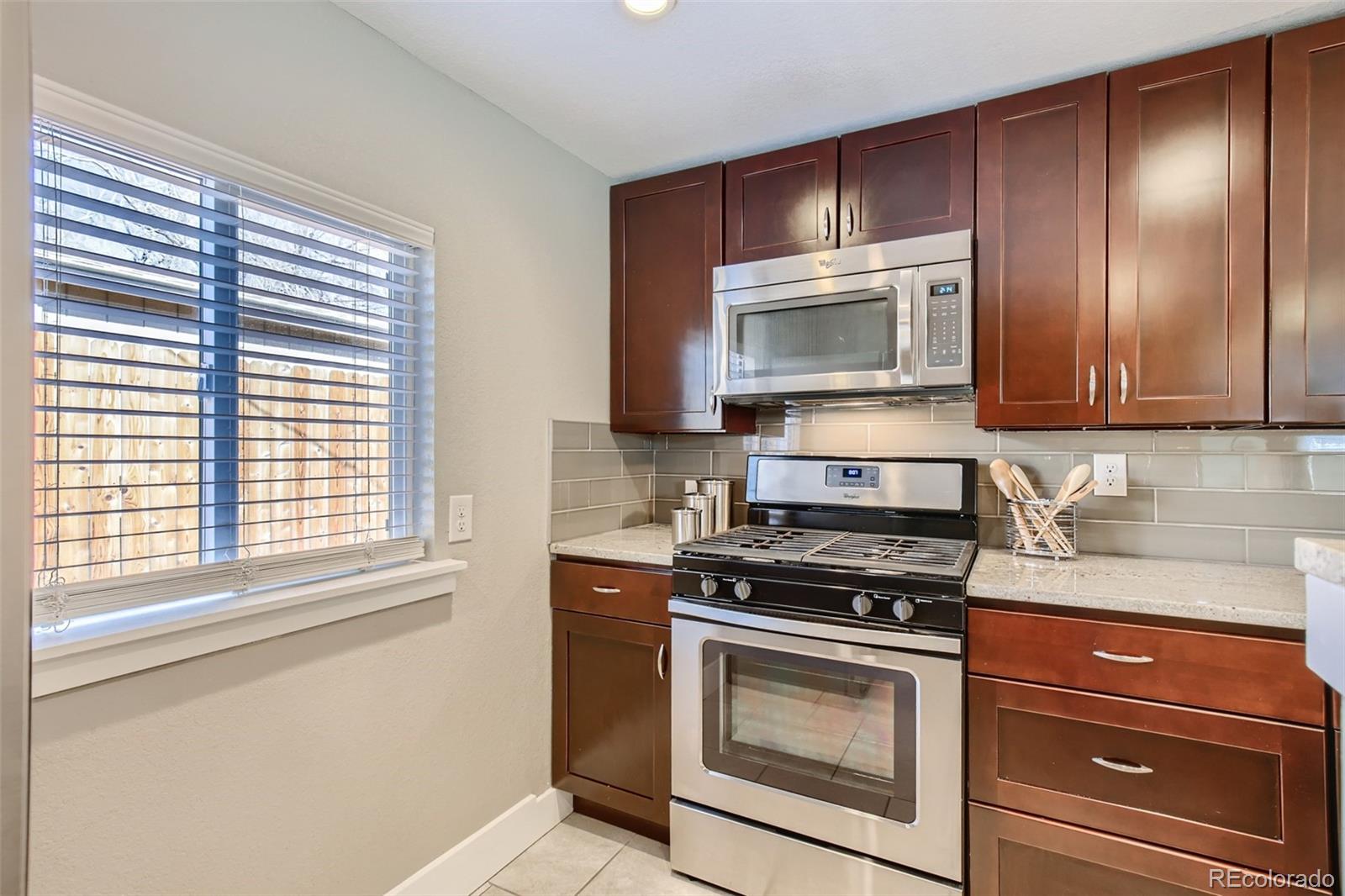 2310 South Decatur Street Denver, CO 80219 - Photo 10 of 27 a kitchen with granite countertop cabinets stainless steel appliances and a window