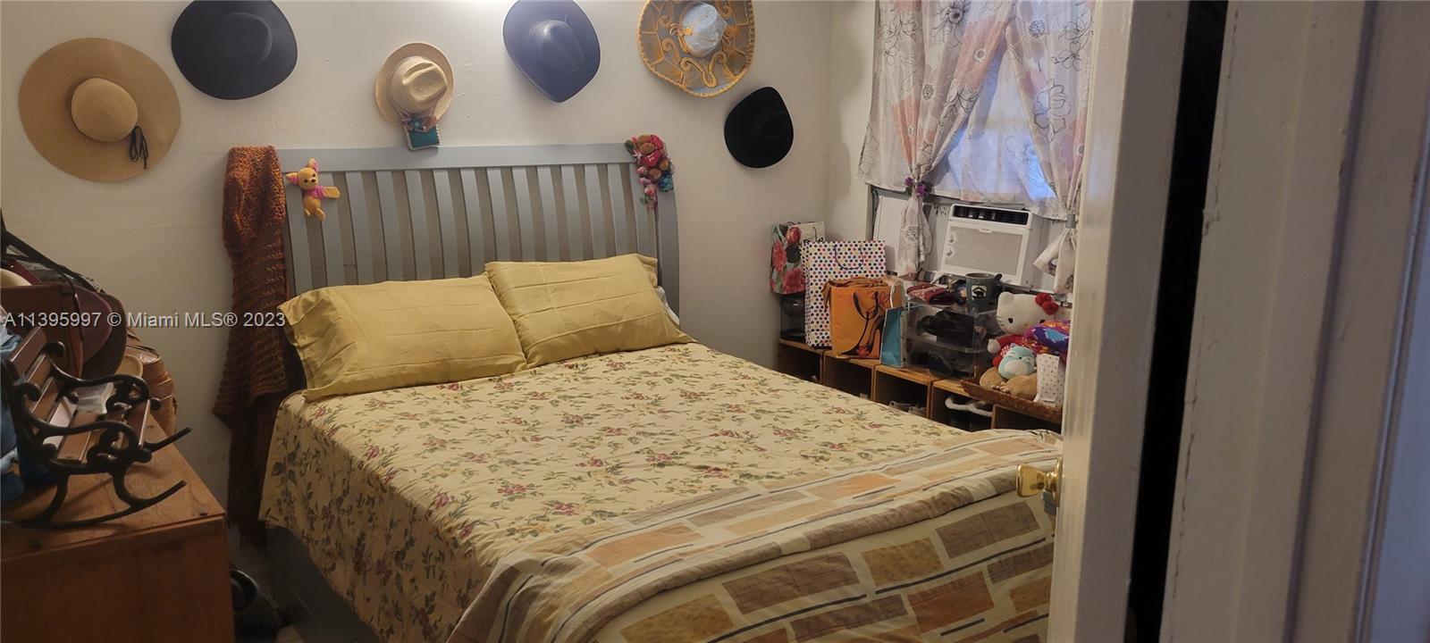 Sunray West North Miami Beach, FL 33162 - Photo 3 of 6 a bed sitting in a bedroom next to a window and a mirror