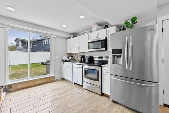 a kitchen with stainless steel appliances a refrigerator sink and microwave