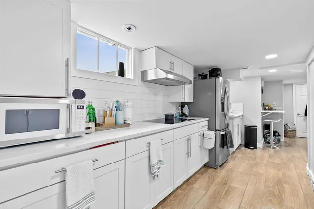 a kitchen with white cabinets and stainless steel appliances