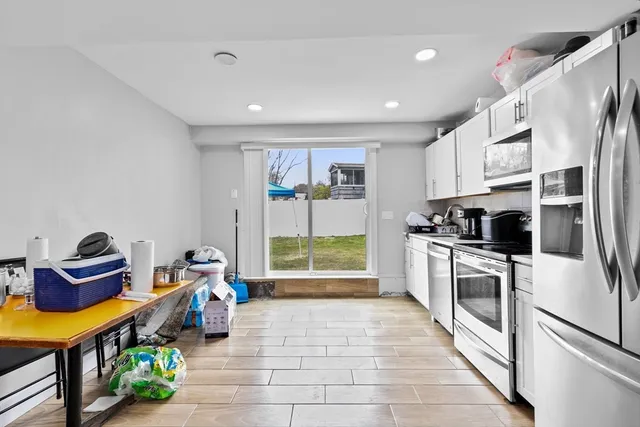 a kitchen with stainless steel appliances granite countertop a refrigerator and a stove