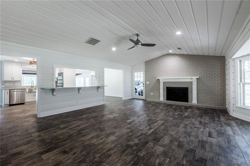 143 Swanson Road Fayetteville, GA 30214 - Photo 13 of 27 an empty room with wooden floor fireplace and windows