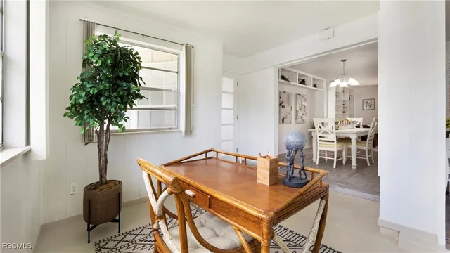 a room with table chairs and potted plants