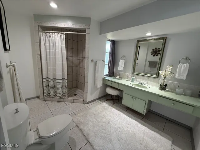 a bathroom with a double vanity sink toilet and shower