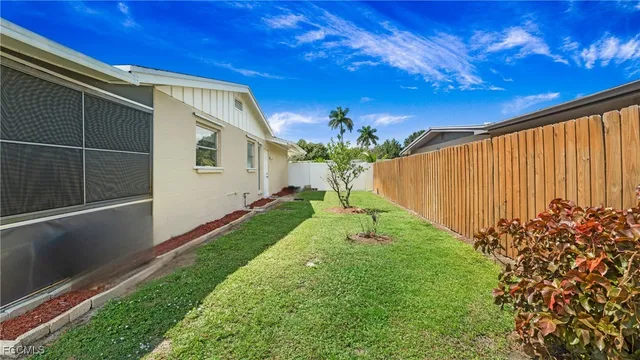 a view of a house with backyard and a tree
