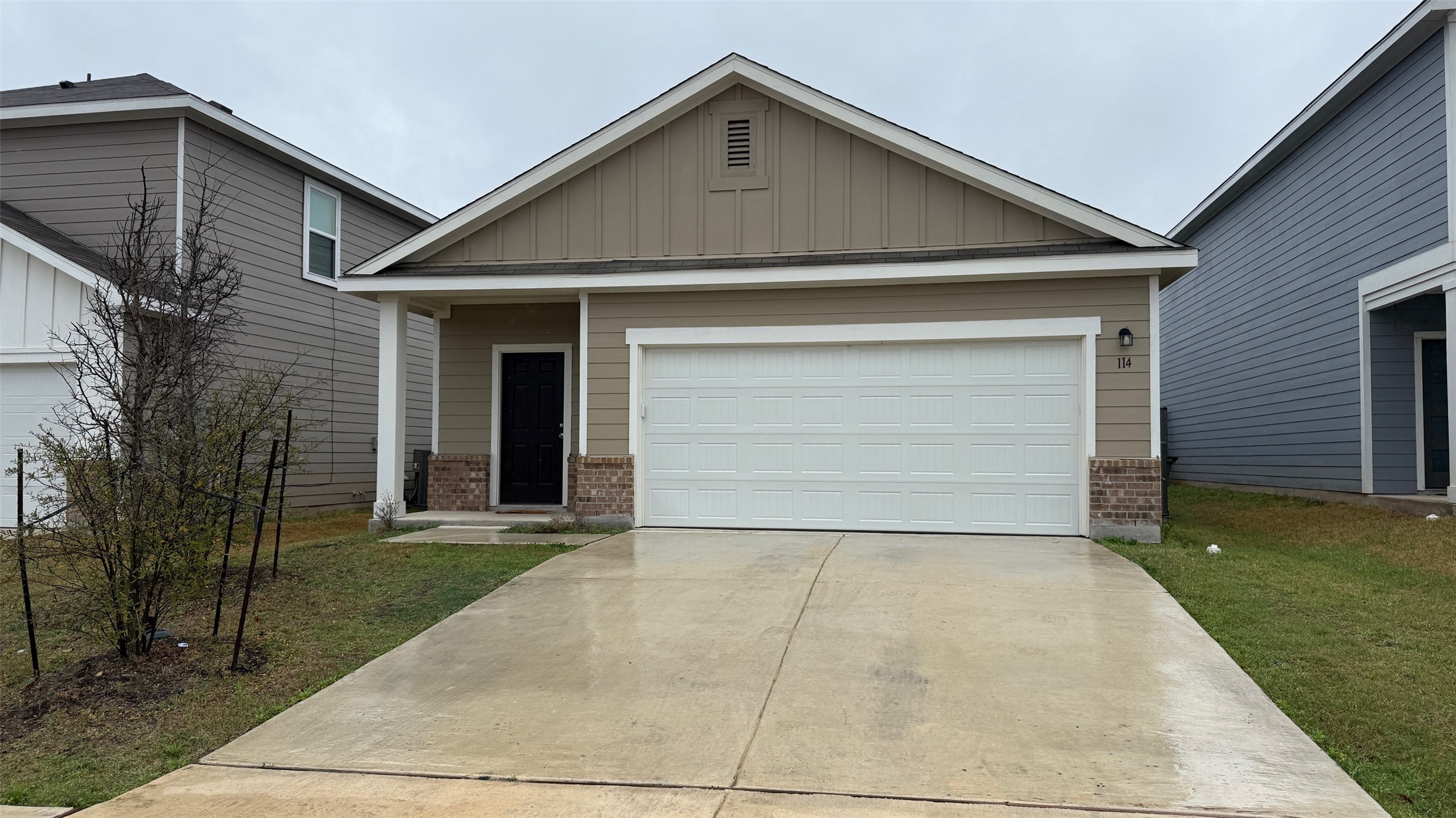 114 Aoudad Road Hutto, TX 78634 - Photo 1 of 22 View of front of home with board and batten siding, concrete driveway, brick siding, and a front yard